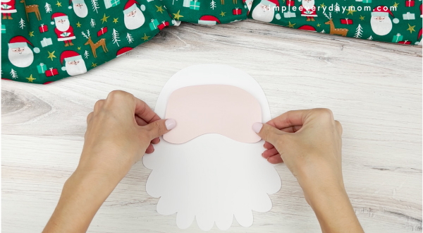 hands placing face of santa on santa name craft