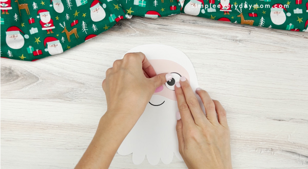 hand placing eye on face of santa name craft