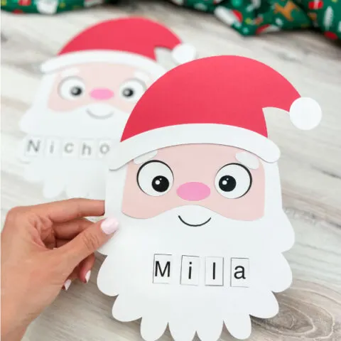 two finished Santa name craft with one being held by hand and one in background