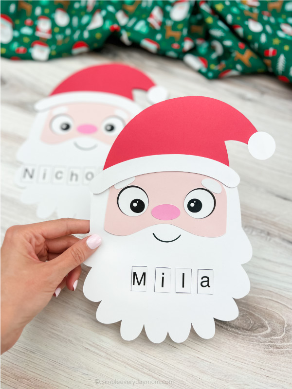 two finished Santa name craft with one being held by hand and one in background