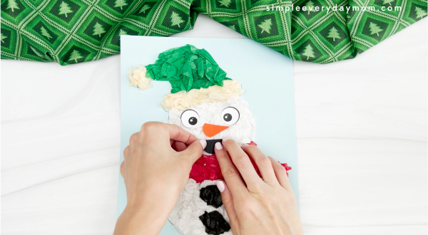 hands gluing mouth to tissue paper snowman