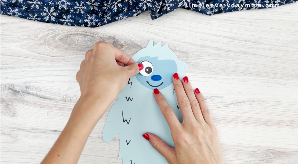 hands gluing eye to abominable snowman craft