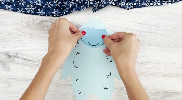 hands gluing face to abominable snowman craft