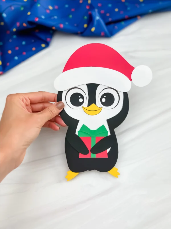hand holding finished Christmas penguin craft