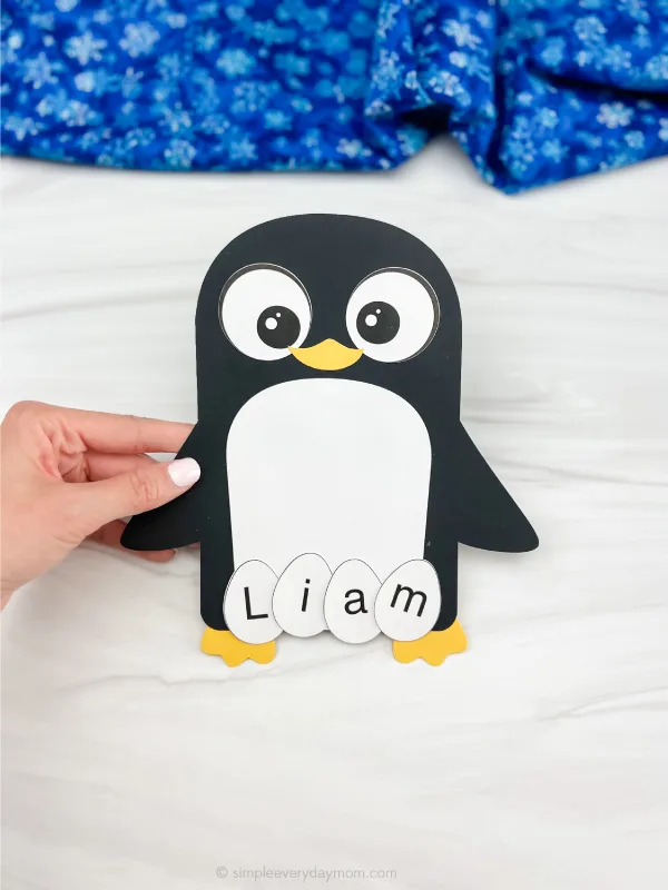 hand holding penguin name craft