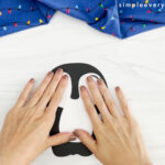hands assembling body of Christmas penguin craft