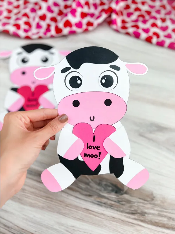 hand holding finished cow valentine craft