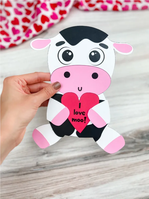 hand holding finished cow valentine craft