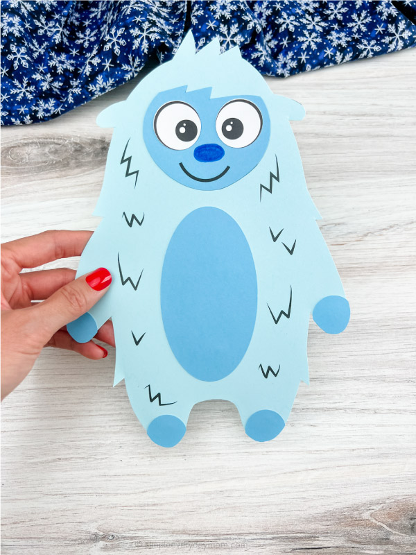 hand holding light blue abominable snowman craft