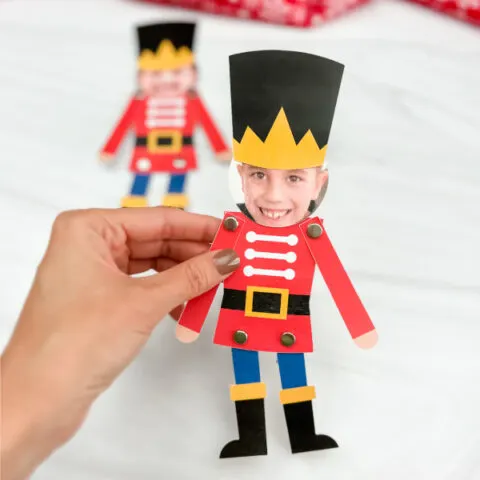 hand holding finished photo nutcracker craft with another version in background