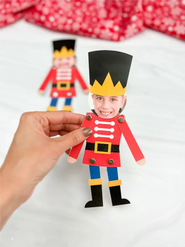 hand holding finished photo nutcracker craft with another version in background