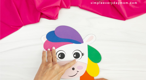hands placing mane onto head of unicorn rainbow puppet