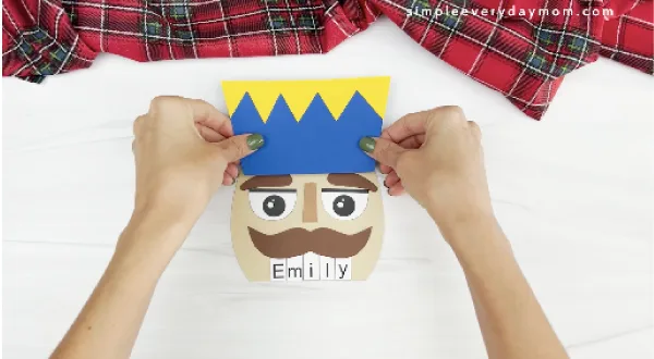 hands gluing hat to nutcracker name craft