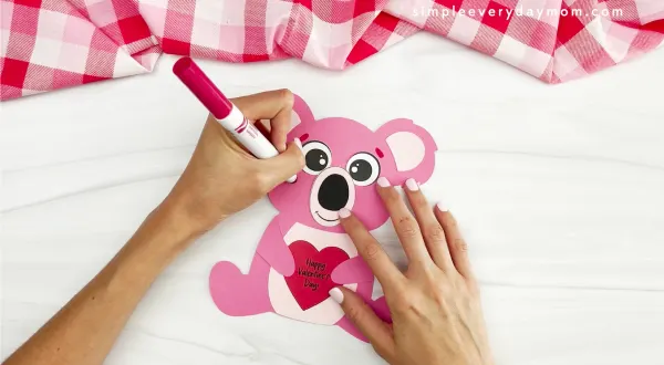 hands drawing parts onto face of koala Valentine craft