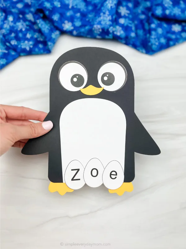 hand holding penguin name craft