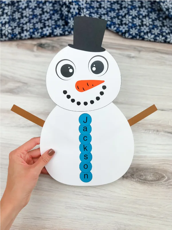 hand holding finished snowman name craft