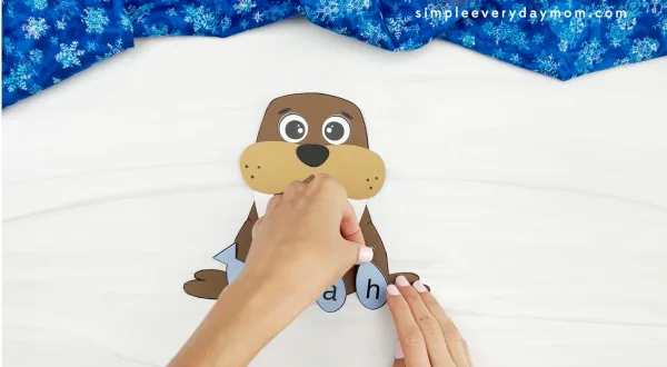 hands placing name onto walrus name craft