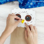 hands gluing beak to owl babies puppet craft