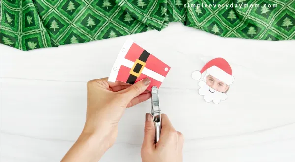 hands using hole punch in santa photo craft