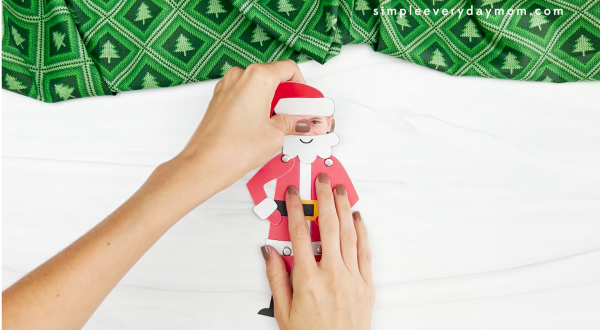 hands placing head onto santa body for santa photo craft
