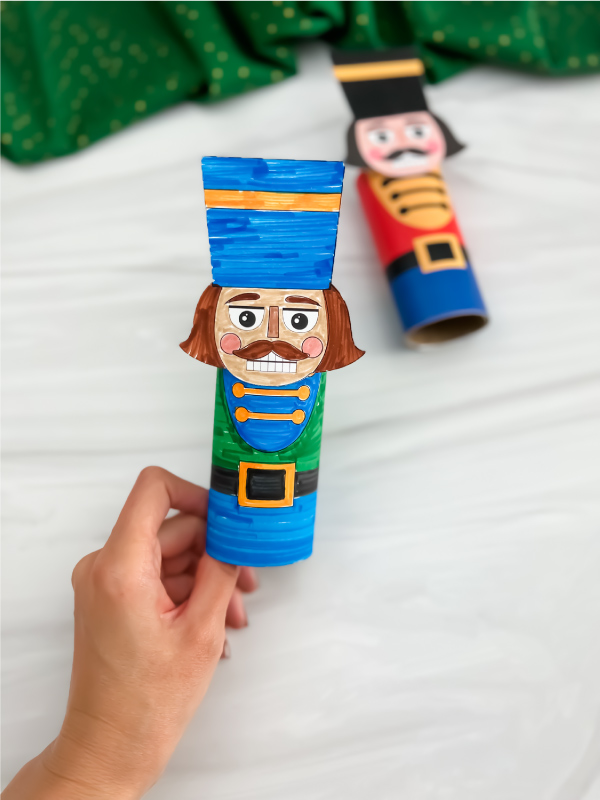 Hand holding finished nutcracker toilet paper roll craft
