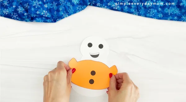 hands placing shirt onto body of Sneezy the snowman