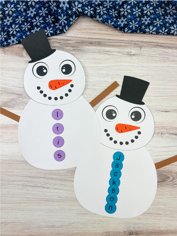 two examples of finished snowman name craft side by side
