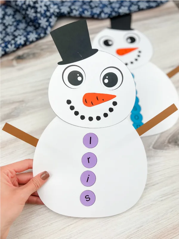 hand holding a finished version of snowman name craft