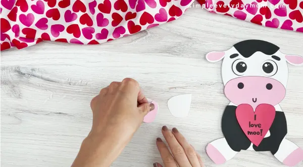 hands assembling parts of cow Valentine craft