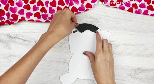 hands assembling parts of body for cow valentine craft