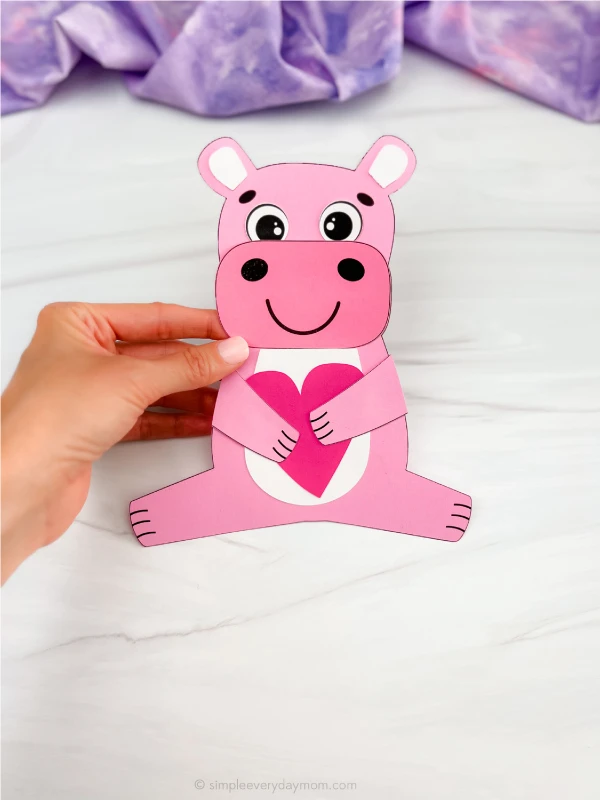 hand holding finished hippo valentine craft pink in color