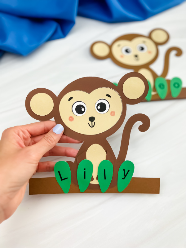 hand holding finished monkey name craft with another one in background