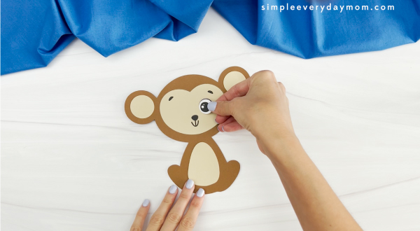 hands gluing eyes onto face of monkey name craft