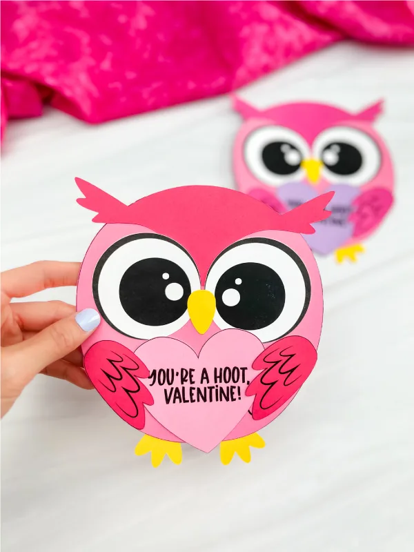 hand holding finished valentine owl craft with another finished owl in background