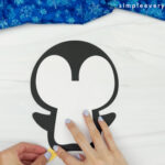 hand gluing the feet of the puffy penguin craft