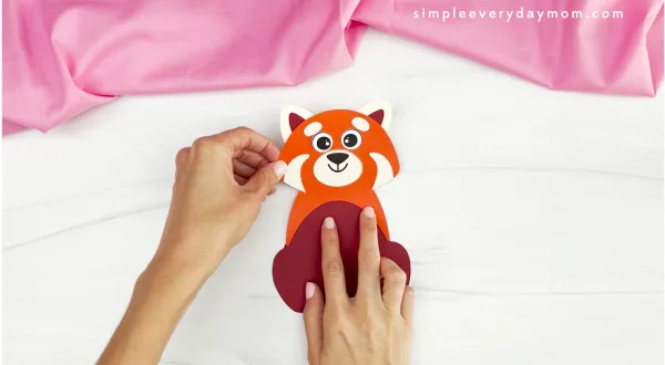 hands assembling parts of red panda valentine craft