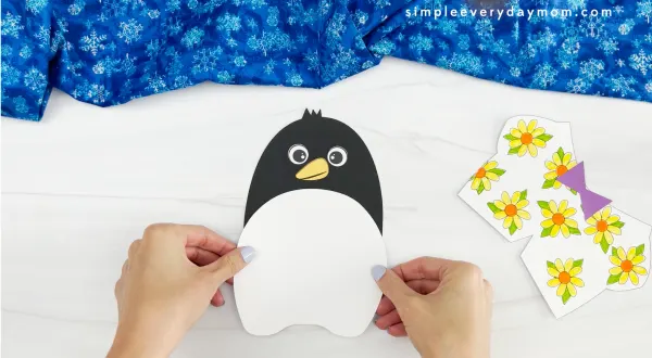 hands gluing body onto Tacky the penguin