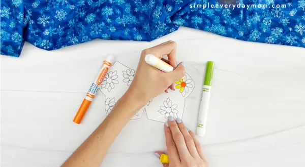 hands using markers to color in the printed template