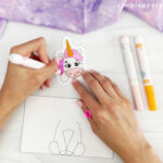 hands using markers to color unicorn head
