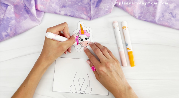 hands using markers to color unicorn head