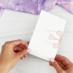 hands gluing unicorn body to toilet roll