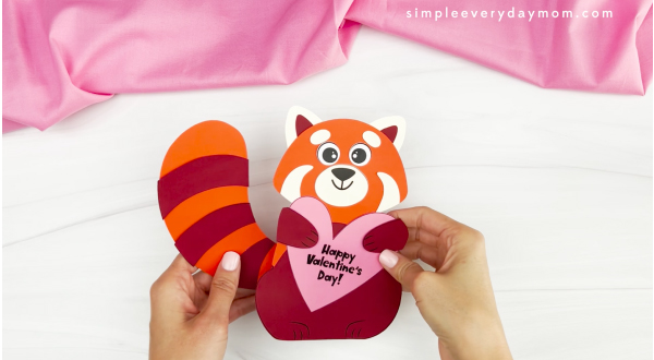 hands holding finished example of red panda valentine craft