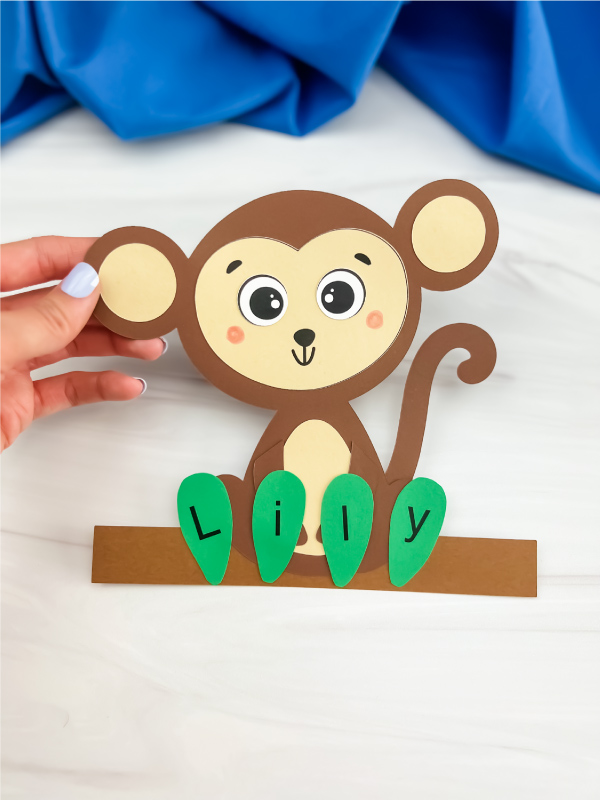 hand holding monkey name craft by the ear