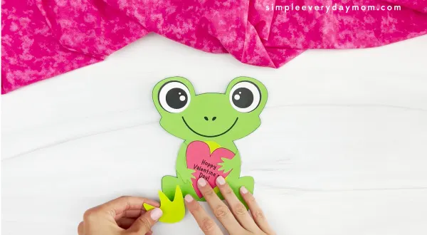 hand gluing frog legs onto body