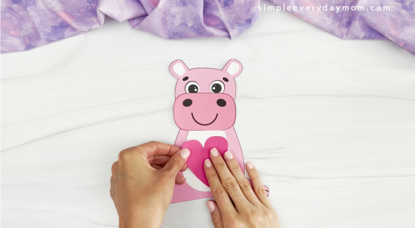 hands gluing heart to hippo Valentine craft