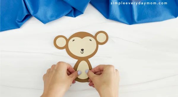 hands placing body onto monkey name craft