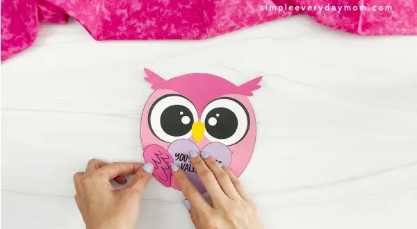 hands gluing wings onto body of Valentine owl craft