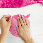 hands gluing parts of owl body together