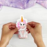 hands gluing unicorn head to unicorn body