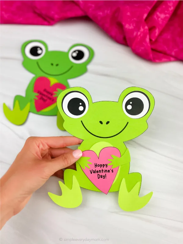 hand holding finished frog valentine craft